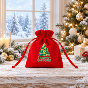 Sacchettino regalo in velluto rosso con albero di Natale scozzese davanti a una finestra innevata